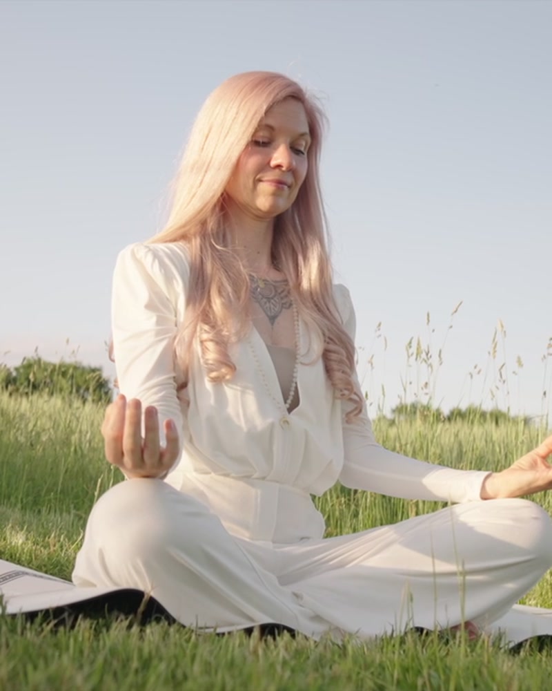 Anny in einer Yogahaltung in der Sommerwiese